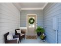 Inviting front porch with cozy chairs, a wreath on the front door, and potted plants creating a warm welcome at 218 Jordan Dr, Woodstock, GA 30188