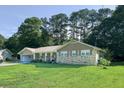 Inviting brick home with a covered front porch and a well-manicured lawn, surrounded by mature trees at 2628 Hickory Trl, Snellville, GA 30078