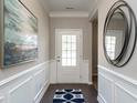 Inviting foyer with decorative wainscoting, art and a round mirror that leads into other areas of the house at 655 Blackshear Trl, Temple, GA 30179