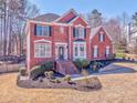 Classic red brick home with black shutters, a landscaped yard, and a welcoming front porch at 4213 Bretdale Nw Run, Kennesaw, GA 30152