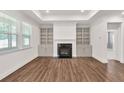 Bright living room with a fireplace, built-in bookshelves, and elegant trim work at 1409 Bluffs Ridge Way, Canton, GA 30114