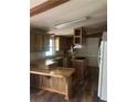 Kitchen with wood cabinets, breakfast bar, countertops, and appliances with island cooktop and wood laminate flooring at 710 Seals Rd, Dallas, GA 30157