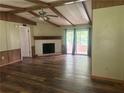 Spacious living room with wood floors, a vaulted ceiling, a fireplace, and sliding glass doors to the outside deck at 710 Seals Rd, Dallas, GA 30157