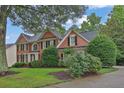 Traditional brick home with black shutters, arched window, landscaping, and a driveway at 283 Heron Lake Ct, Lawrenceville, GA 30043
