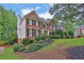 Brick two-story home on a landscaped hill with white trim and black shutters at 283 Heron Lake Ct, Lawrenceville, GA 30043