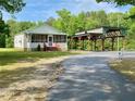 Charming home with a screened-in porch and convenient covered parking, set against a backdrop of green trees at 505 Sandhill Hickory Level Rd, Carrollton, GA 30116