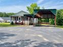 Quaint home featuring a screened-in porch and covered parking, surrounded by a spacious paved driveway at 505 Sandhill Hickory Level Rd, Carrollton, GA 30116