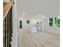 Open-concept living room with light-colored wood floors, modern lighting, and a view of the kitchen at 1888 Goddard Se St, Atlanta, GA 30315