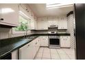 Functional kitchen featuring white cabinets, green countertops, and modern appliances for efficient meal preparation at 4137 Wellington Hills Ln, Snellville, GA 30039