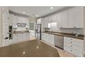 Spacious kitchen featuring white cabinets, stainless steel appliances, and a large island at 8675 Hope Vine, Roswell, GA 30076