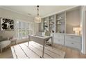 Bright home office featuring built-in shelving, hardwood floors, and neutral decor at 8675 Hope Vine, Roswell, GA 30076