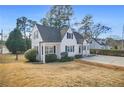 Quaint cottage style home with lush green landscaping and mature trees at 1831 Dresden Dr, Brookhaven, GA 30319