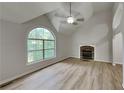 Bright living room with vaulted ceiling, fireplace, large window, and sleek wood-look flooring at 26 Nottingham Nw Dr, Cartersville, GA 30121