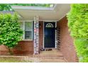 Charming front porch with decorative columns and a black front door at 3967 Norman Rd, Stone Mountain, GA 30083