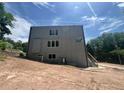 Modern two-story home featuring a gray exterior, multiple windows, and a staircase on a sloped lot at 4107 Danforth Sw Rd, Atlanta, GA 30331
