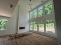 Bright, spacious living room with large windows, hardwood floors, fireplace, and soaring vaulted ceiling at 4107 Danforth Sw Rd, Atlanta, GA 30331