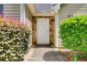 Close-up view of the front entrance adorned with stone accents and surrounded by vibrant shrubbery at 414 Pamela Ct, Mcdonough, GA 30252