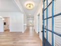 Elegant entryway features hardwood floors, wainscoting, modern light fixture and a blue front door at 4377 Hosch Reserve Dr, Buford, GA 30519