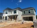 Charming two-story home with brick facade, gray accents, and attached garage under a clear blue sky at 4377 Hosch Reserve Dr, Buford, GA 30519