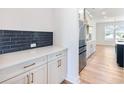 Modern kitchen with white cabinets, quartz counters, stainless appliances and blue tile backsplash at 4377 Hosch Reserve Dr, Buford, GA 30519
