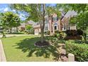 Brick two-story home with a well-manicured lawn, two-car garage and a classic architectural style at 580 Washington Way, Cumming, GA 30040
