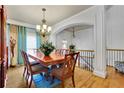 Elegant dining room with hardwood floors, chandelier, and decorative archway at 10765 Arlington Pt, Alpharetta, GA 30022