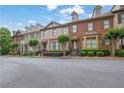 Street view of a row of brick townhomes with manicured lawns and mature trees at 10765 Arlington Pt, Alpharetta, GA 30022