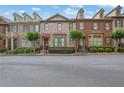 Beautiful row of brick townhomes featuring manicured lawns and inviting curb appeal at 10765 Arlington Pt, Alpharetta, GA 30022