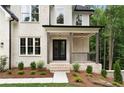 Inviting covered front porch with brick steps, dark wood columns, and wrought iron railing at 3915 Ashley Trace Sw Ct, Lilburn, GA 30047