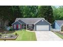 Inviting single-story home with blue siding, red shutters, well-manicured lawn, and a two-car garage at 5742 Riverside Walk Dr, Sugar Hill, GA 30518