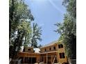 New construction showing the framed structure with the roof being installed against a beautiful blue sky at 1330 Twelve Oaks Nw Cir, Atlanta, GA 30327