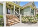 Lovely covered front porch with stone steps, wrought iron railing and complementary light green siding at 46 Grand Georgian Ne Ct, Cartersville, GA 30121