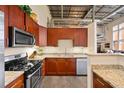 Kitchen boasts granite countertops, stainless steel appliances, cherry wood cabinets, and an adjacent spiral staircase at 572 Edgewood Se Ave # 303, Atlanta, GA 30312