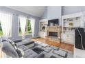 Spacious living room featuring a stone fireplace, built-in shelving, and hardwood floors, filled with natural light at 1614 Rucker Rd, Alpharetta, GA 30009