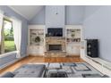 Bright living room with a stone fireplace, built-in bookcases, hardwood floors and an abundance of natural light at 1614 Rucker Rd, Alpharetta, GA 30009