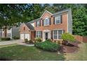 Traditional two-story brick house featuring a landscaped yard, driveway, and mature trees at 4321 Sugar Maple Chase Nw, Acworth, GA 30101