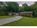 Charming single-story home with stone and brick exterior, surrounded by lush greenery and a well-manicured lawn at 4717 Westhampton Dr, Tucker, GA 30084