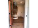 Inviting entryway featuring hardwood floors, wood stairs, and a stylish front door at 115 Pinecone Pkwy, Alpharetta, GA 30022