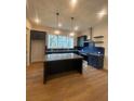 Modern kitchen with an island, stainless steel appliances, and stylish dark blue cabinetry at 115 Pinecone Pkwy, Alpharetta, GA 30022