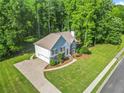 Aerial view of a two-story home with an attached garage, surrounded by lush greenery and a long driveway at 4638 Arrow Wind Dr, Powder Springs, GA 30127