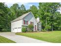 Charming two-story home with a well-manicured lawn, stone accents, red shutters, a bright red front door, and a side garage at 4638 Arrow Wind Dr, Powder Springs, GA 30127