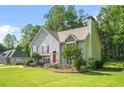 Charming two-story home with a well-manicured lawn, stone accents, red shutters, and a bright red front door, with driveway at 4638 Arrow Wind Dr, Powder Springs, GA 30127