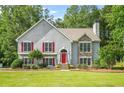 Traditional home with red shutters, stone accents, and lush landscaping on a well-kept lawn at 4638 Arrow Wind Dr, Powder Springs, GA 30127