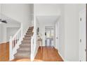 Bright entryway with wood flooring, staircase, and access to multiple rooms at 3327 James Harbor Way, Lawrenceville, GA 30044