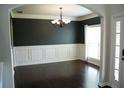 Elegant dining room with dark hardwood floors, chair rail, crown molding and a decorative chandelier at 4020 Alligator Pt, Cumming, GA 30028