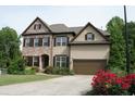 Beautiful two-story house with brick and siding, well-kept lawn, and colorful flowers at 4020 Alligator Pt, Cumming, GA 30028