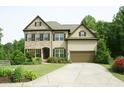 Beautiful two-story home with a two-car garage, brick accents, and lush greenery at 4020 Alligator Pt, Cumming, GA 30028