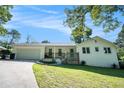 Charming white brick home featuring a covered front porch, attached garage and lush green lawn at 4384 Herschel Rd, College Park, GA 30337