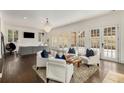 Open-concept living room with comfortable seating, a fireplace, and multiple French doors at 591 E Morningside Ne Dr, Atlanta, GA 30324