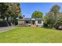 Quaint one-story house with manicured front lawn, garden beds, and exterior details at 727 Channing Nw Dr, Atlanta, GA 30318
